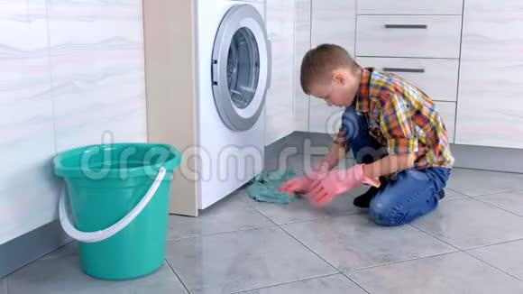 穿橡胶手套的男孩在厨房里洗地板儿童的家庭责任视频的预览图