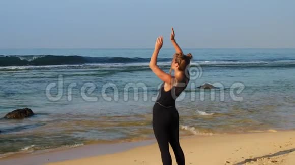 在沙滩上挥舞大海的运动女士视频的预览图