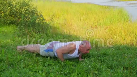 一个中年男人早上在湖边做俯卧撑视频的预览图