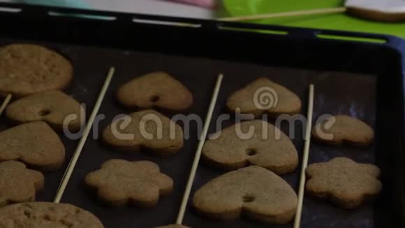 心形姜饼糖霜彩釉的糕点袋旁边的烤盘上有饼干视频的预览图