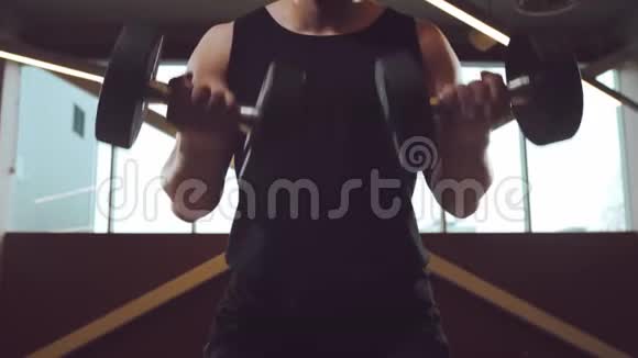运动英俊的男运动员在健身房用哑铃工作强壮健康的健美腹部训练视频的预览图