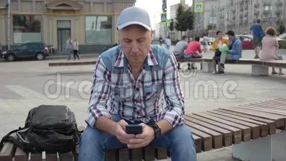 白种人坐在长凳上写短信视频的预览图