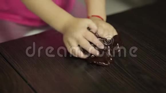 孩子的手和棕色黏液玩得很开心小孩玩手工制作的玩具黏液视频的预览图