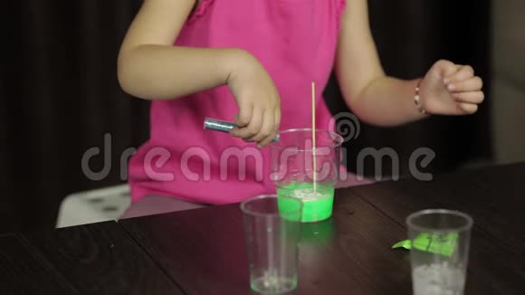 孩子的手做绿色黏液混合配料玩手工玩具视频的预览图