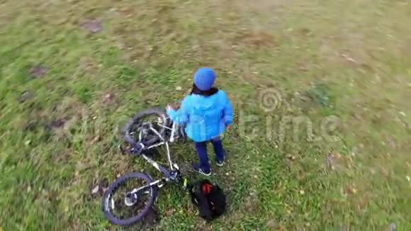 女自行车骑手放松休息在绿色草坪空中射击运动快乐的生活方式鼓舞人心的秋天视频的预览图