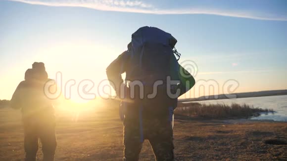 两名游客一起背着背包慢动作行走在阳光照射下的生活方式中剪影视频的预览图