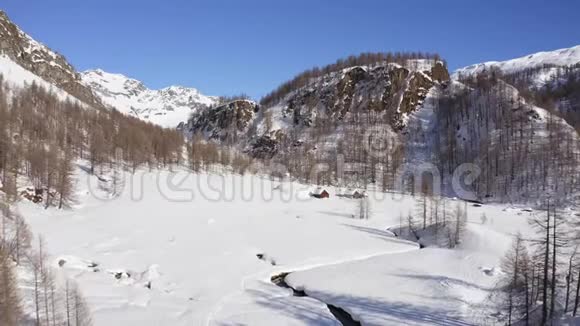 飞越冬季仙境雪山山谷在阳光明媚的冬日冬天的景色有住客和行人视频的预览图