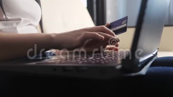 女孩制作在线生活方式销售购物概念与笔记本电脑数字平板电脑黑发女人躺在沙发上看着商店视频的预览图