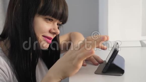 女孩在智能手机上浏览在线生活方式页面在数码购物中看网上购物的女孩视频的预览图