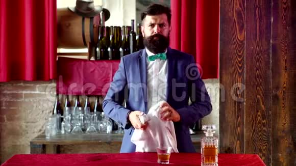 酒保拿着一杯威士忌时尚优雅的胡子男酒保拿着威士忌酒杯奢侈的酒精饮料视频的预览图