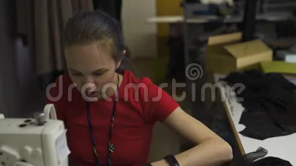 电脑朋克时装设计师在她的工作室缝纫使用机器白种人白色妇女穿红色t恤和视频的预览图