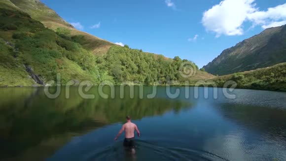 慢镜头特写活跃的男性游客先跳进山里清爽的湖里年轻人视频的预览图