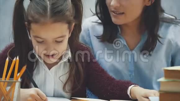 关门妈妈帮我女儿在厨房做作业妈妈和女儿从事阅读他们在一个视频的预览图