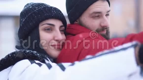 站在冬天后院的男人和女人的肖像幸福的情侣远望女孩紧紧拥抱男友视频的预览图