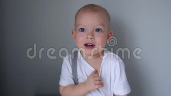 穿白色T恤的两岁蓝眼睛男孩的肖像男孩很尴尬孩子们情绪快乐的童年视频的预览图