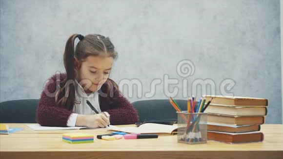 妈妈和女儿坐在灰色背景的桌子旁写作业交流视频的预览图