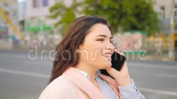 友好电话手机微笑女士通话街道视频的预览图
