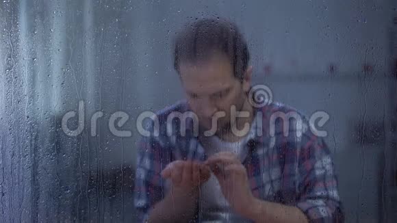 沮丧的男人在雨天看肺x光不治之症癌症视频的预览图