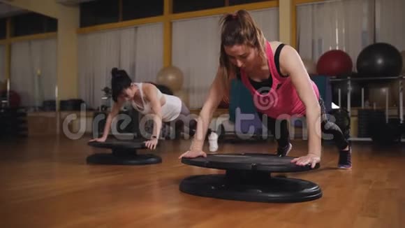 两个女人用平衡板在健身房做有氧运动视频的预览图