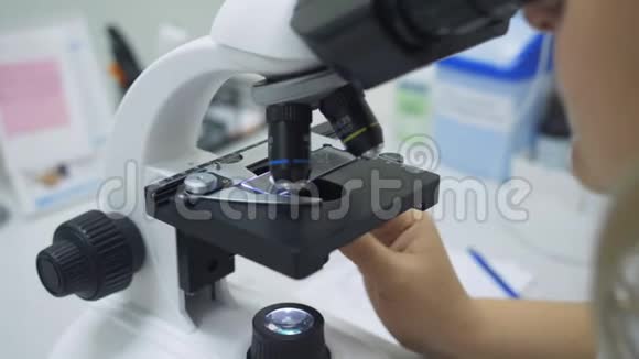女生物学家在实验室里用显微镜做特写视频的预览图