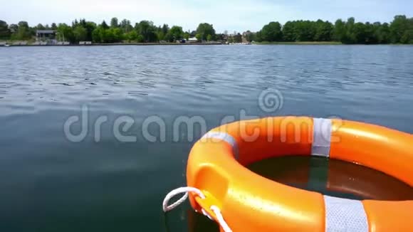 橙色救生浮标漂浮在远离海岸的湖水上万向节运动视频的预览图