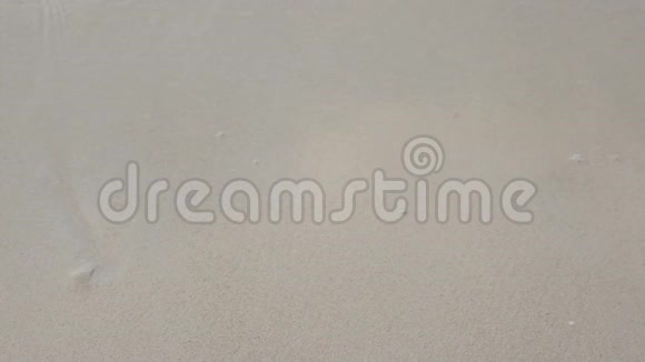 一个人用手在沙子上写着工作这个词用波浪冲着字母视频的预览图