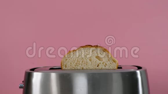 烤面包机白色面包在粉红色背景关闭视频的预览图