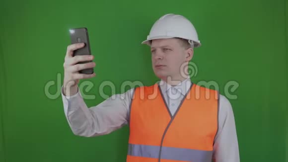 建设者或工程师在建筑工程的智能手机上拍照铬化戴着白色头盔的头儿视频的预览图