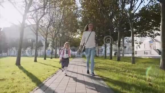 年轻的妈妈和一个女孩牵着手奔跑着微笑着稳定正面视图视频的预览图