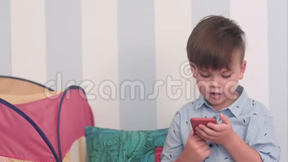 兴奋的小男孩在他的手机上读到一条信息视频的预览图
