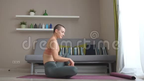 穿着运动训练服的美丽自信的健身女孩正在客厅做伸展瑜伽练习视频的预览图