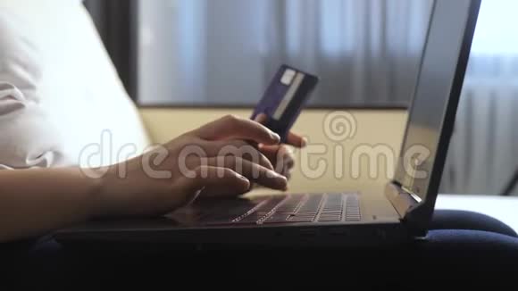 女孩的生活方式使网上销售购物概念与数字平板电脑黑发女人躺在沙发上看网上商店视频的预览图