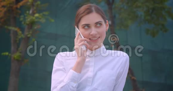 一位年轻的高加索女商人在公园户外打电话的特写照片视频的预览图