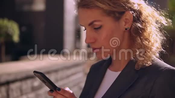 户外智能手机上美丽的女士短信视频的预览图