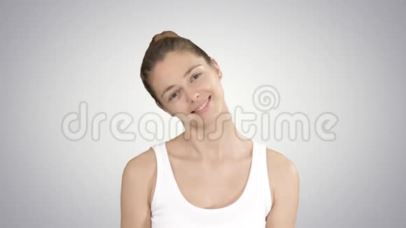 微笑的女人放松她的颈部肌肉做伸展运动的梯度背景视频的预览图