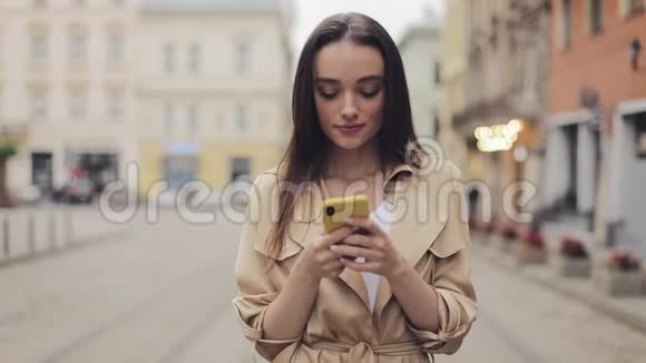 美丽的少女手持手机聊天笑站在城市背景下的沟通理念视频的预览图