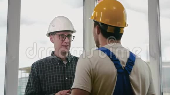老板或首席与工人工程师握手并给予工资视频的预览图