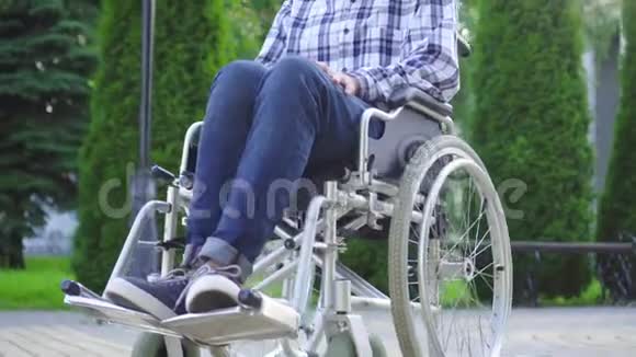在公园轮椅上残疾的亚裔青年画像视频的预览图