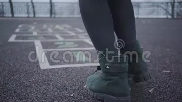 在沥青上画的跳跳游戏中特写女性腿开朗的女孩或女人在户外玩得很开心视频的预览图