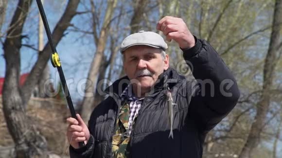 一位老人展示了一条刚钓上来的鱼视频的预览图