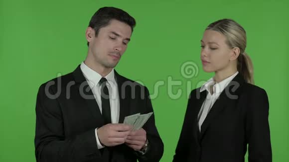年轻男性专业人员给予女性专业人员美元Chroma关键视频的预览图