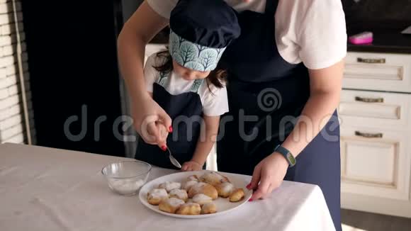 妈妈的特写和一个小女儿撒上糖粉饼干视频的预览图
