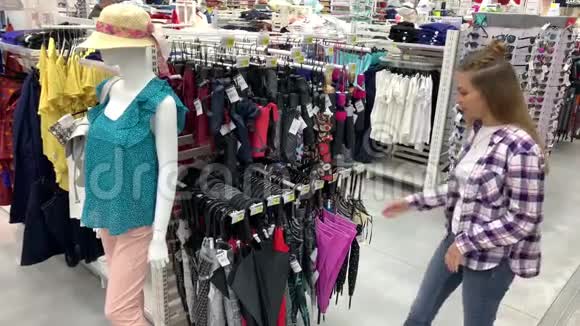 女人在超市里选一把伞女孩拿起一把粉红色的伞打开在伞下旋转4K慢Mo视频的预览图