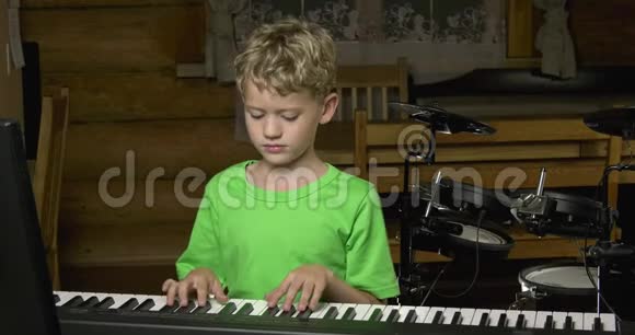 小男孩用电钢琴的黑键演奏简单的旋律视频的预览图