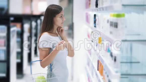 化妆品店的女孩选择奶油看货上架慢动作视频的预览图