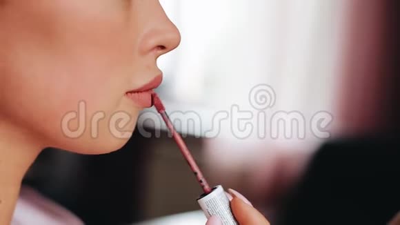 女孩把口红涂在嘴唇上不错的特写视频的预览图
