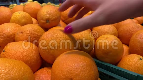 在商店买东西特写女人拿橘子4K慢慢视频的预览图