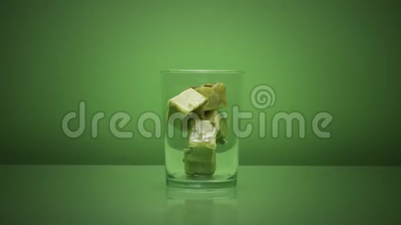在绿色的玻璃上加入抹茶冰块和牛奶视频的预览图