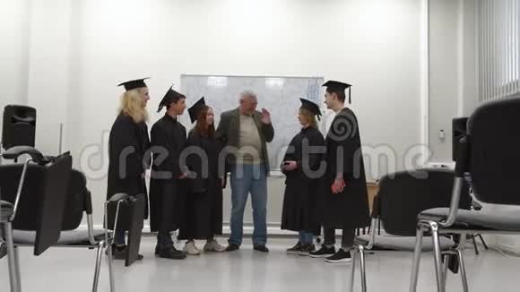 穿制服的毕业生和教授交谈视频的预览图