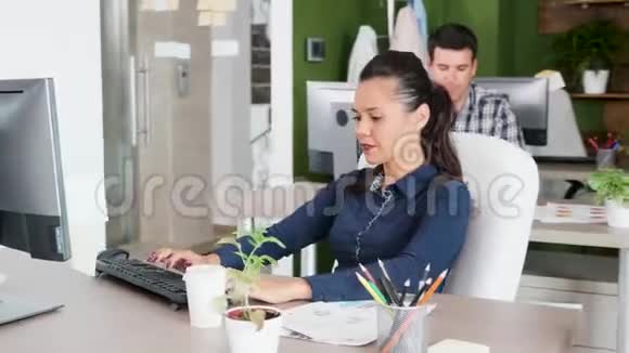 年轻漂亮的女企业家在办公室打字和喝咖啡视频的预览图